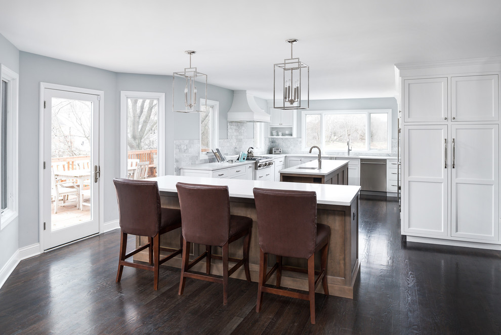 Design ideas for a mid-sized transitional u-shaped eat-in kitchen in Chicago with an undermount sink, white cabinets, quartz benchtops, marble splashback, stainless steel appliances, dark hardwood floors, brown floor, white benchtop, recessed-panel cabinets, grey splashback and with island.