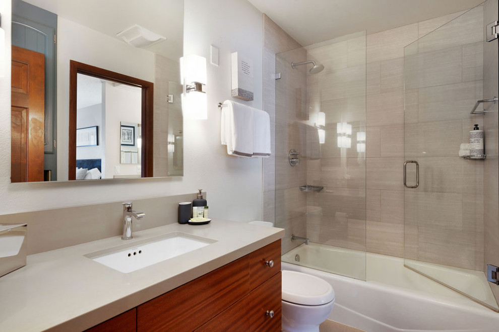На фото: маленькая ванная комната в стиле неоклассика (современная классика) с плоскими фасадами, коричневыми фасадами, накладной ванной, душем над ванной, унитазом-моноблоком, бежевой плиткой, керамогранитной плиткой, белыми стенами, полом из линолеума, душевой кабиной, накладной раковиной, столешницей из искусственного кварца, коричневым полом, душем с распашными дверями, коричневой столешницей, тумбой под одну раковину и встроенной тумбой для на участке и в саду с