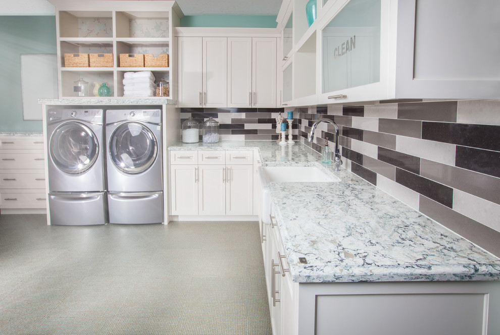 Inspiration for a large transitional l-shaped laundry room in Minneapolis with a farmhouse sink, shaker cabinets, white cabinets, quartz benchtops, blue walls, laminate floors and a side-by-side washer and dryer.
