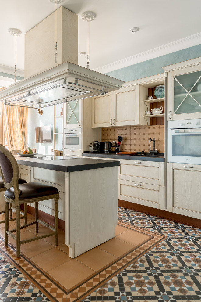 Design ideas for a traditional single-wall separate kitchen in Moscow with shaker cabinets, white cabinets, beige splashback, white appliances, with island, multi-coloured floor and black benchtop.