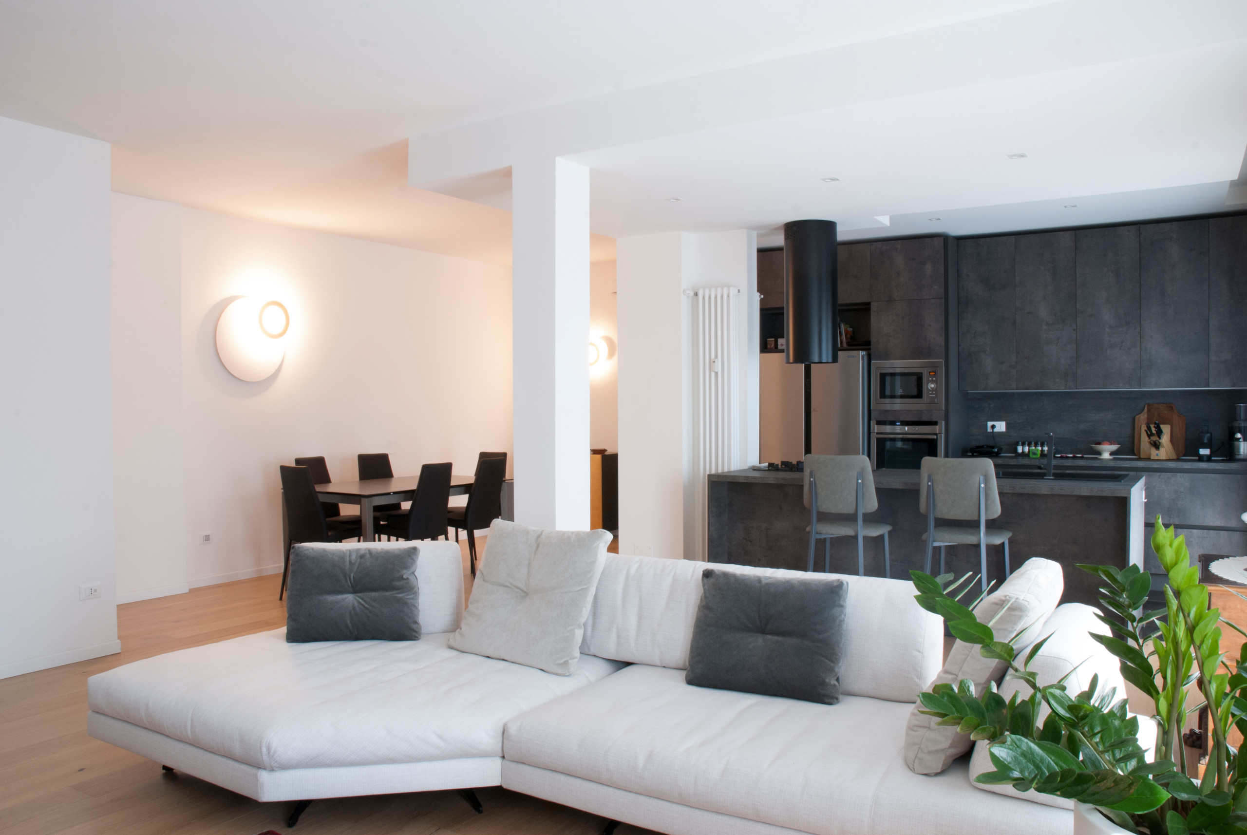 Foto di un grande soggiorno design aperto con pareti bianche, pavimento in legno massello medio e parete attrezzata