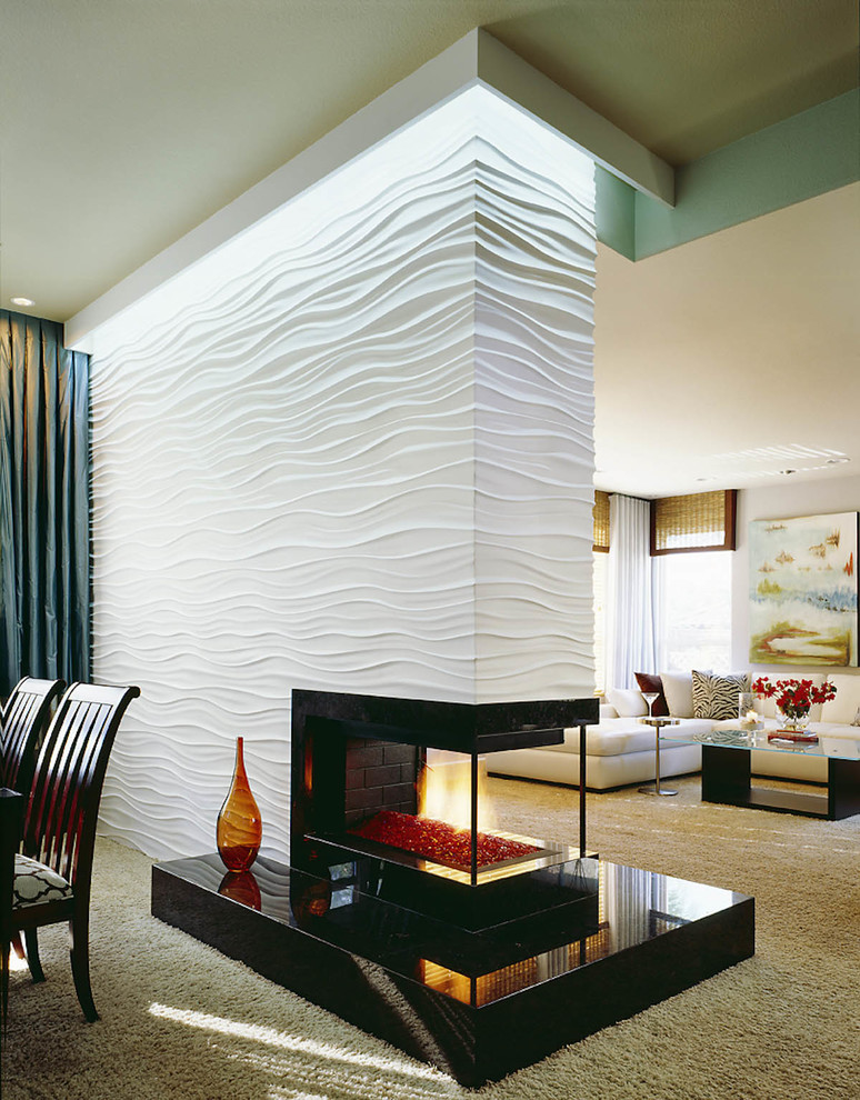 This is an example of a contemporary open concept living room in San Diego with a two-sided fireplace.