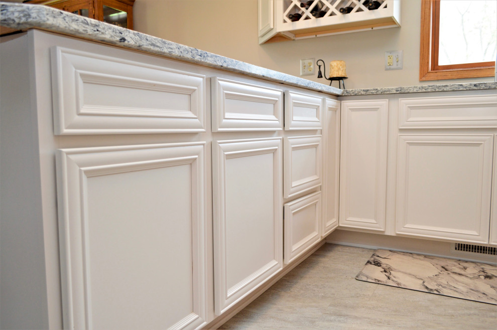 Eat-in kitchen - mid-sized transitional l-shaped eat-in kitchen idea in Chicago with an undermount sink, recessed-panel cabinets, white cabinets, quartzite countertops, stainless steel appliances, a peninsula and gray countertops