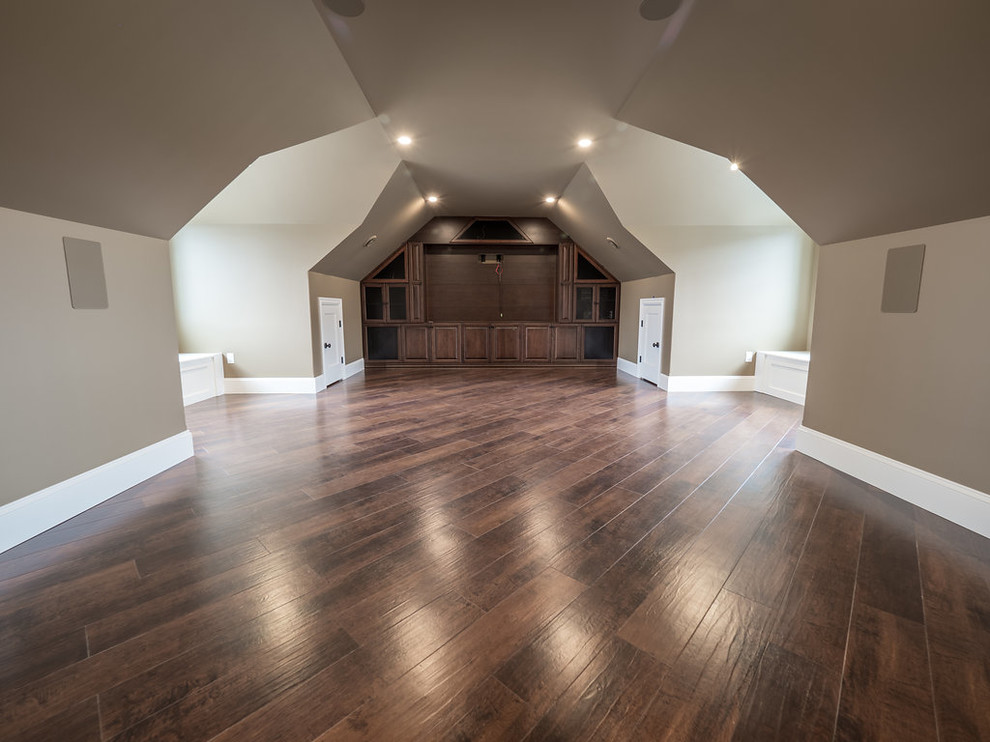This is an example of a large country enclosed home theatre in Edmonton with beige walls, vinyl floors, a built-in media wall and multi-coloured floor.