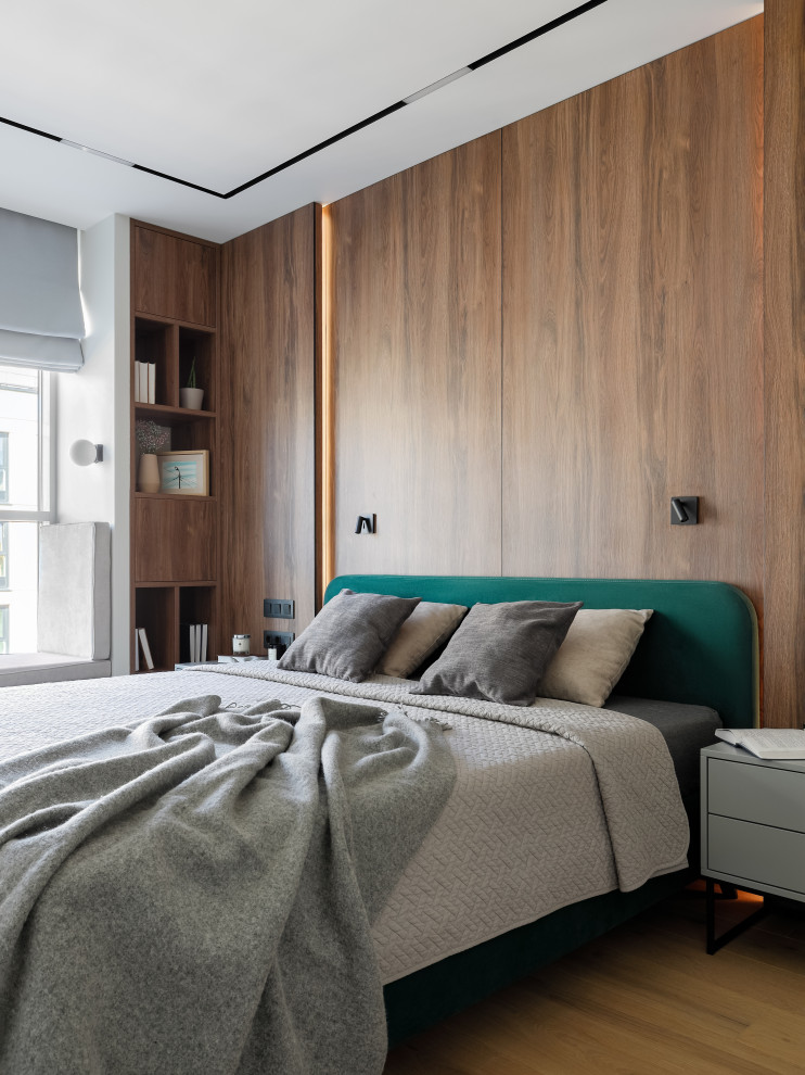 Ejemplo de dormitorio principal y blanco y madera actual de tamaño medio con paredes blancas, suelo de madera clara, suelo beige y boiserie