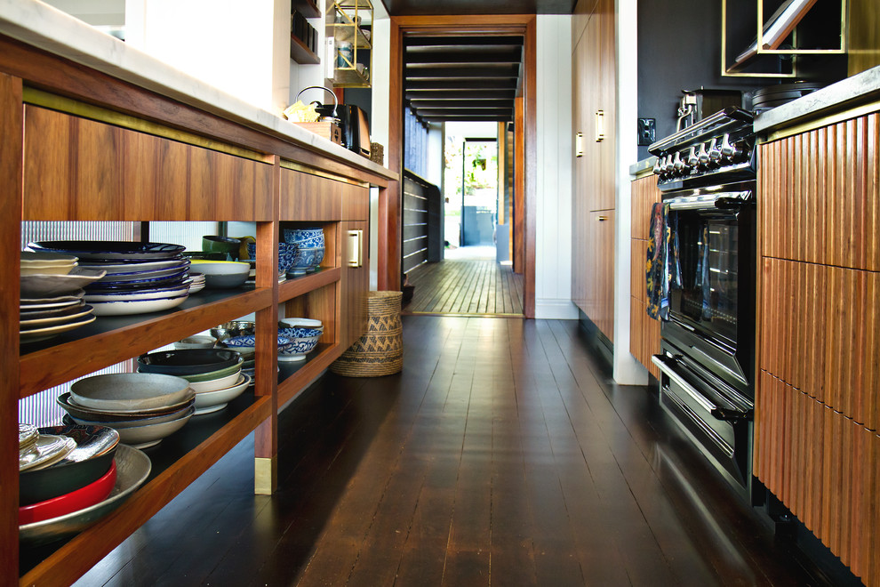 Inspiration for an industrial galley eat-in kitchen in Brisbane with an undermount sink, louvered cabinets, medium wood cabinets, granite benchtops, black appliances, with island and grey benchtop.
