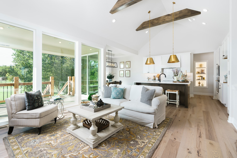 Design ideas for a mid-sized scandinavian open concept family room in Wichita with white walls, light hardwood floors, a standard fireplace, a brick fireplace surround, brown floor, no tv and exposed beam.
