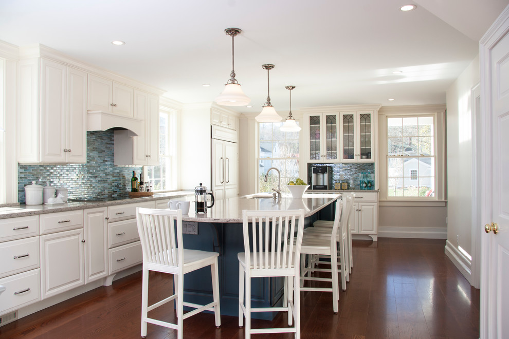 Inspiration for a beach style u-shaped separate kitchen in Boston with an undermount sink, raised-panel cabinets, white cabinets, quartz benchtops, blue splashback, glass tile splashback and stainless steel appliances.