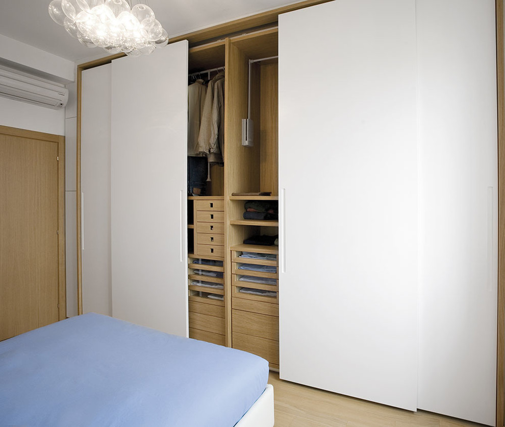 Photo of a mid-sized modern master bedroom in Milan with light hardwood floors and white walls.