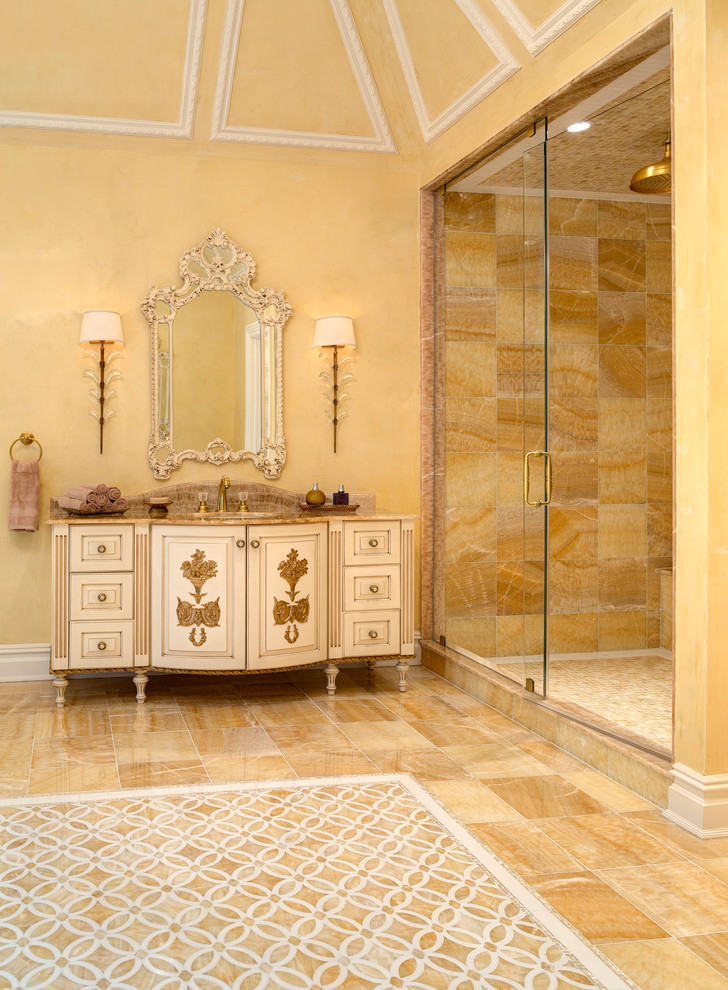 This is an example of a large mediterranean master bathroom in New York with furniture-like cabinets, beige cabinets, an alcove shower, beige walls, an undermount sink, granite benchtops, beige floor and a sliding shower screen.