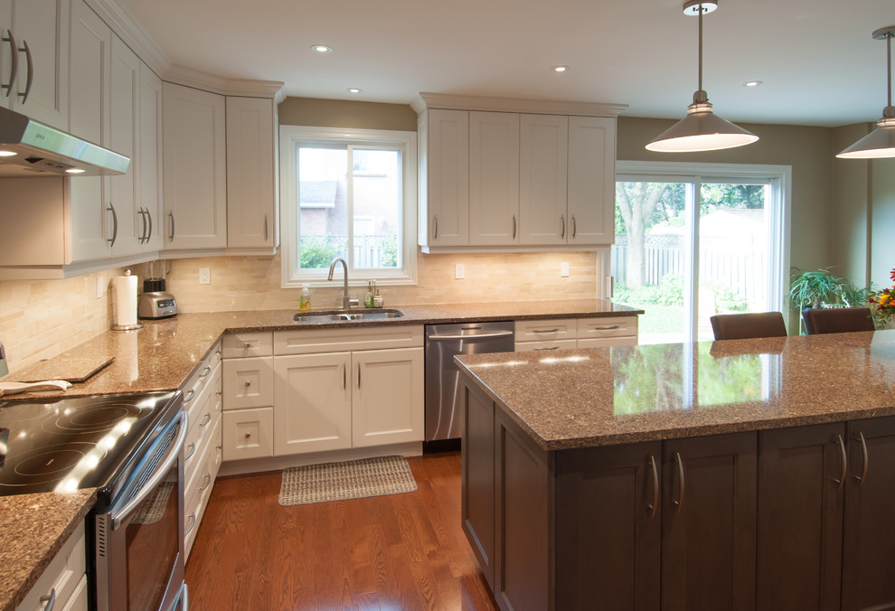 Enclosed kitchen - large transitional u-shaped medium tone wood floor enclosed kitchen idea in Toronto with a double-bowl sink, shaker cabinets, white cabinets, granite countertops, beige backsplash, ceramic backsplash, stainless steel appliances and an island