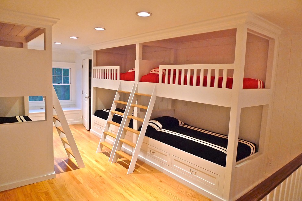 This is an example of a mid-sized beach style gender-neutral kids' bedroom in Providence with beige walls and light hardwood floors.