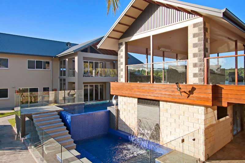 Design ideas for a large contemporary backyard l-shaped aboveground pool in Brisbane with a pool house and tile.