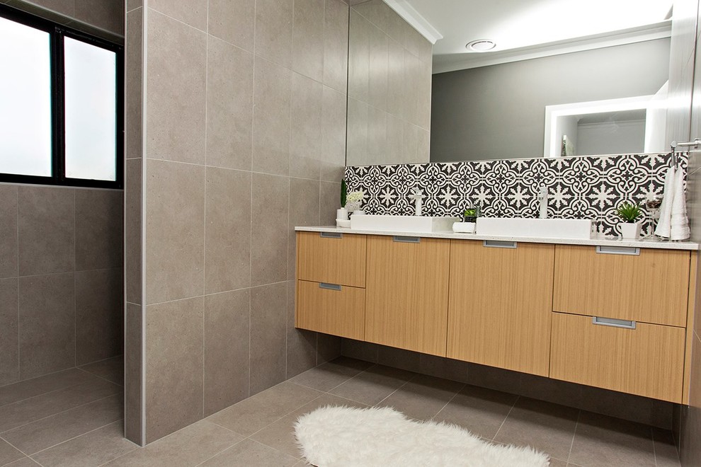 This is an example of a mid-sized contemporary master bathroom in Sydney with flat-panel cabinets, light wood cabinets, an open shower, a one-piece toilet, black and white tile, cement tile, grey walls, ceramic floors, a drop-in sink, engineered quartz benchtops, grey floor and an open shower.