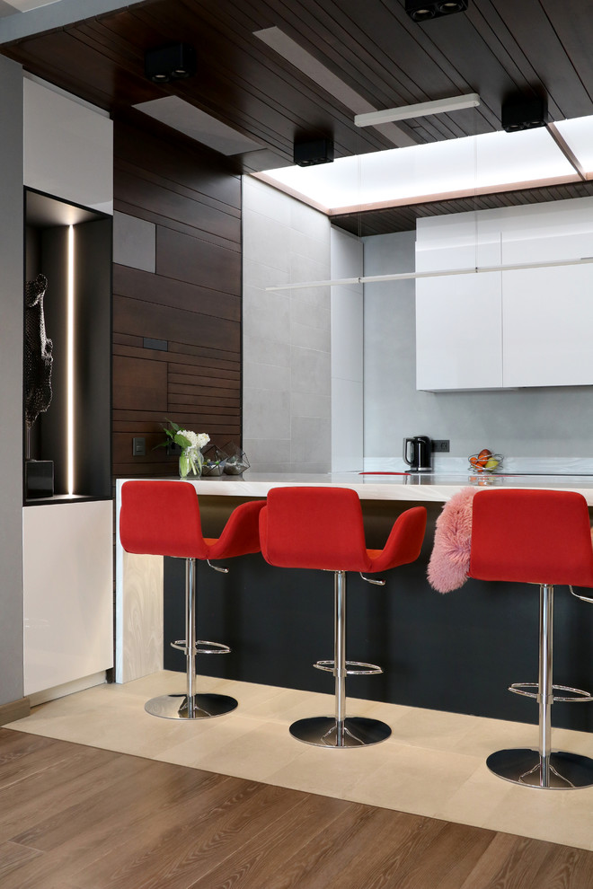 Design ideas for a contemporary kitchen in Moscow with flat-panel cabinets, white cabinets, white benchtop and beige floor.