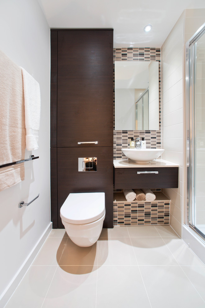 Contemporary powder room in London with a vessel sink, flat-panel cabinets, dark wood cabinets, beige tile, matchstick tile, white walls and a wall-mount toilet.