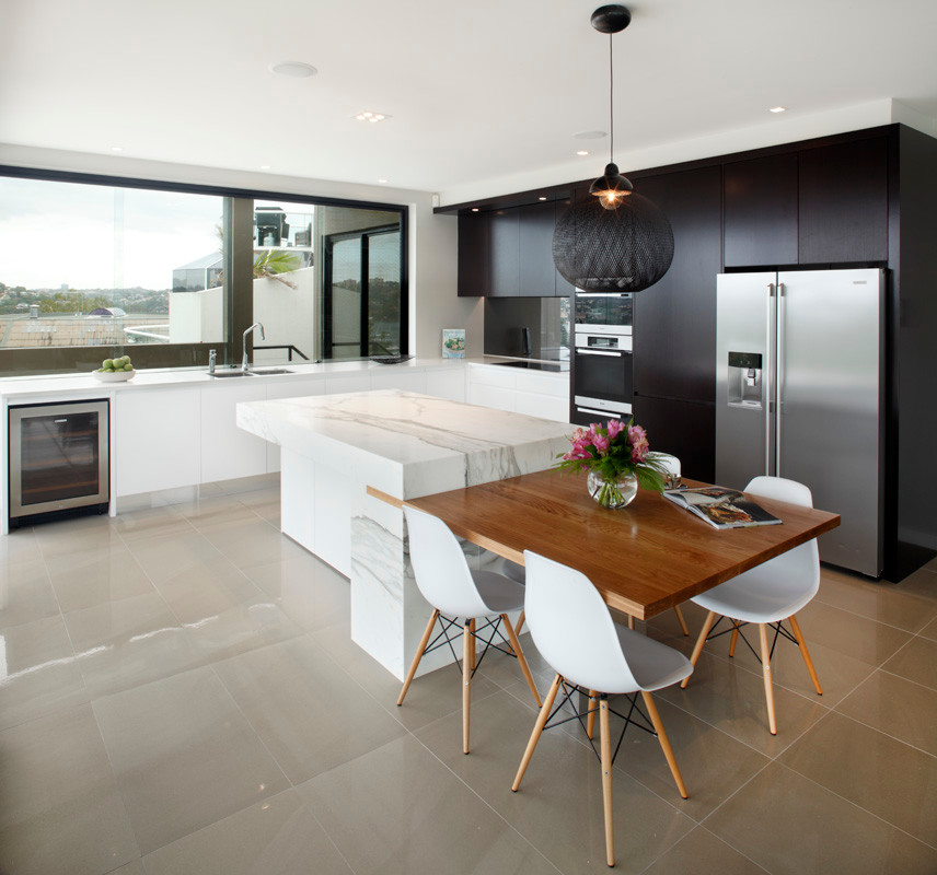 Inspiration for a mid-sized modern l-shaped kitchen in Sydney with an undermount sink, flat-panel cabinets, black cabinets, marble benchtops, metallic splashback, glass sheet splashback, stainless steel appliances, porcelain floors and with island.