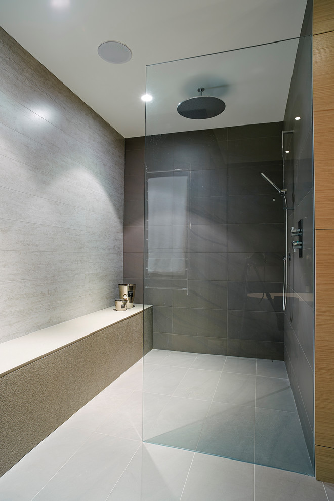 Design ideas for a mid-sized contemporary master bathroom in Vancouver with a vessel sink, flat-panel cabinets, light wood cabinets, engineered quartz benchtops, a freestanding tub, an open shower, gray tile, porcelain tile, grey walls and porcelain floors.