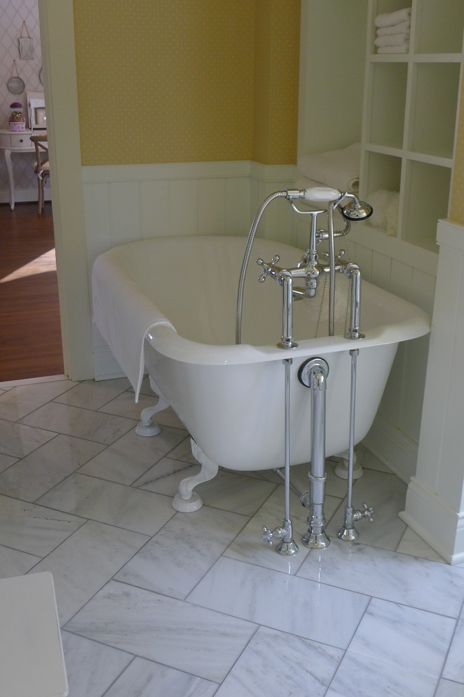 Photo of a traditional bathroom in Indianapolis with an undermount sink, beige cabinets, marble benchtops, a claw-foot tub, an alcove shower, a one-piece toilet, beige tile and stone tile.