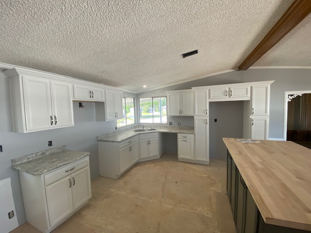 Inspiration for a mid-sized l-shaped eat-in kitchen remodel with a double-bowl sink, flat-panel cabinets, white cabinets, laminate countertops, an island and gray countertops