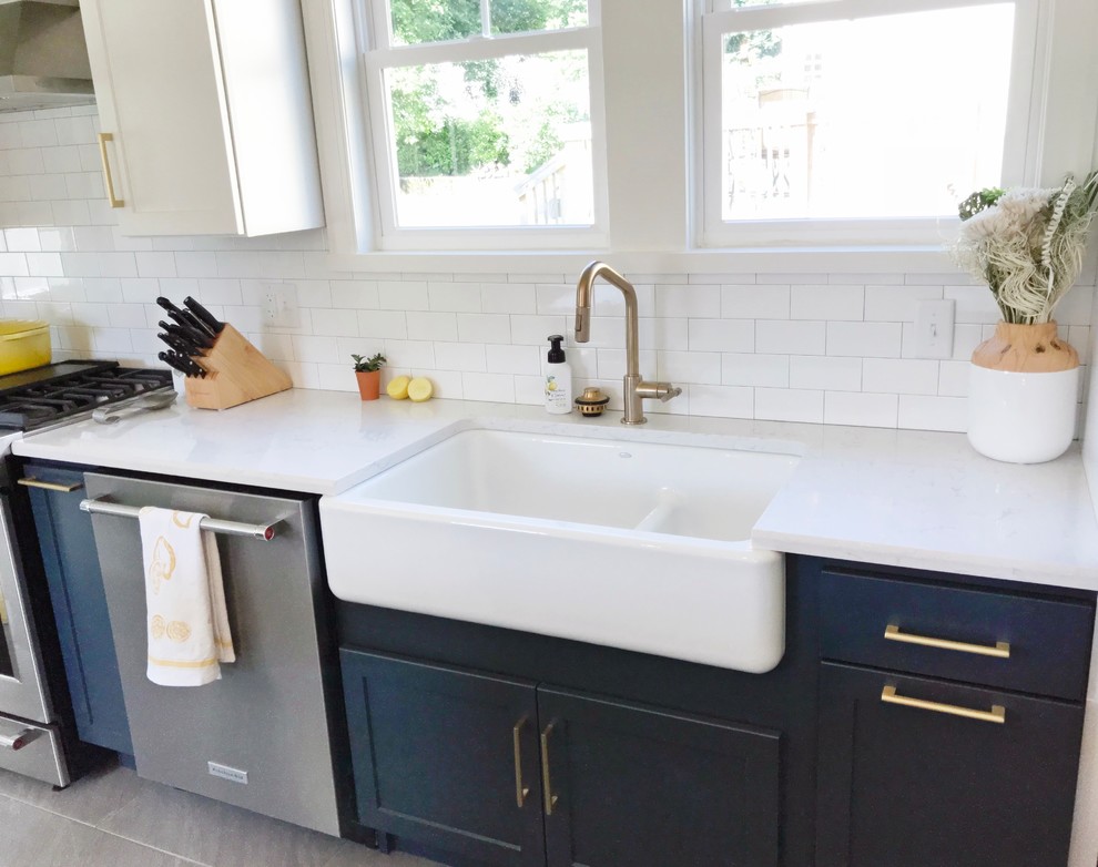Transitional gray floor kitchen photo with a farmhouse sink, quartz countertops and stainless steel appliances