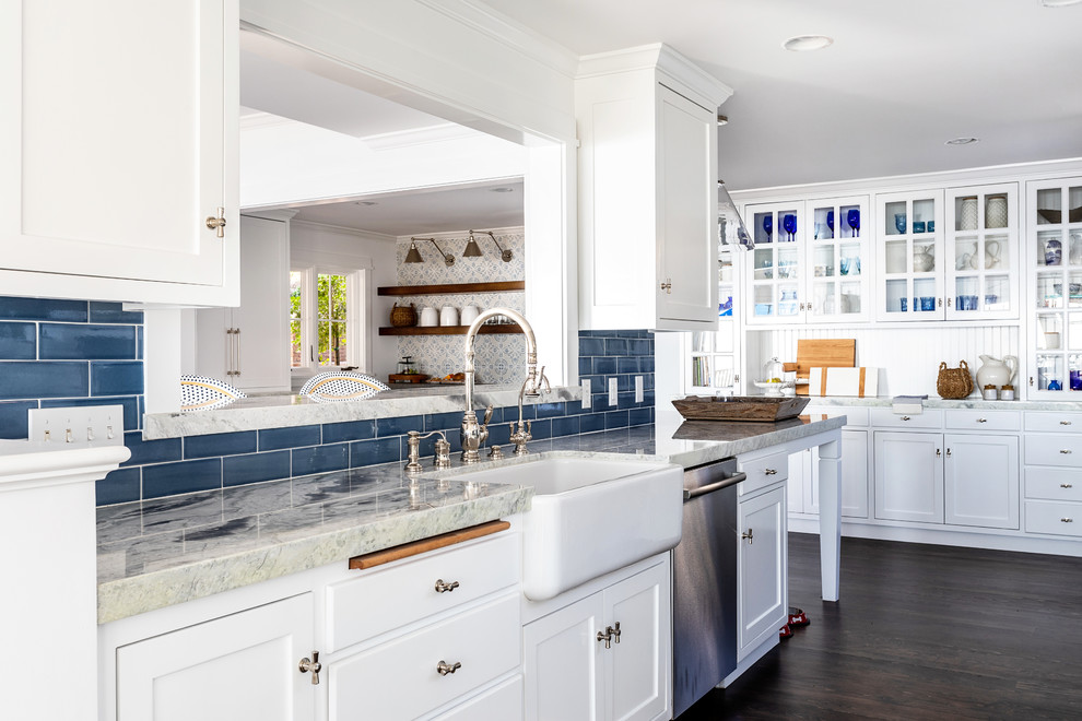 Design ideas for a mid-sized beach style l-shaped eat-in kitchen in Sacramento with an undermount sink, shaker cabinets, white cabinets, granite benchtops, blue splashback, ceramic splashback, stainless steel appliances, dark hardwood floors, no island and grey benchtop.