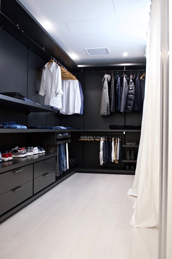 Large modern men's walk-in wardrobe in Other with open cabinets, grey cabinets, light hardwood floors and white floor.