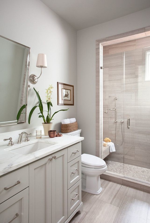 Mid-sized traditional 3/4 bathroom in Toronto with recessed-panel cabinets, a two-piece toilet, gray tile, grey walls, an undermount sink, white cabinets, an alcove shower, ceramic tile, ceramic floors, engineered quartz benchtops, beige floor, a hinged shower door and a shower seat.