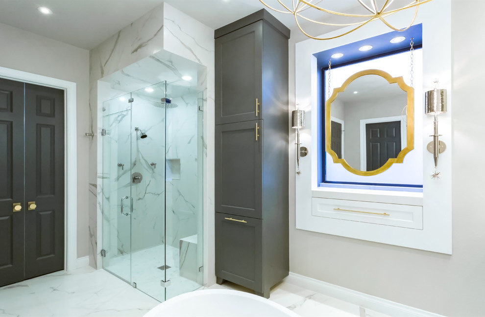 Design ideas for a mid-sized transitional master bathroom in Houston with furniture-like cabinets, grey cabinets, a freestanding tub, a curbless shower, a wall-mount toilet, white tile, porcelain tile, grey walls, marble floors, a vessel sink and quartzite benchtops.