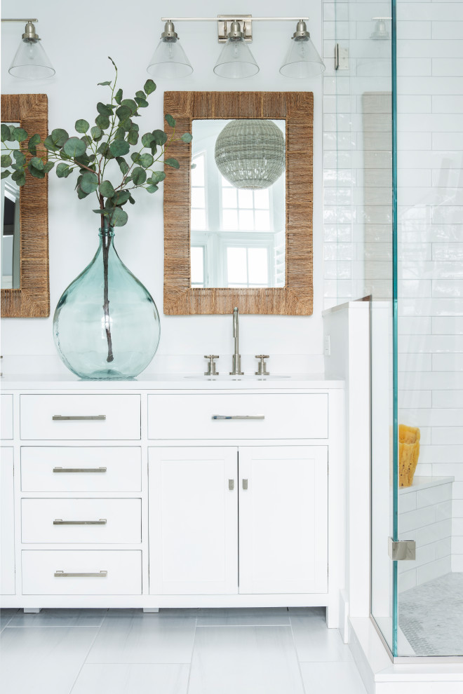 This is an example of a small beach style master bathroom in Other with shaker cabinets, white cabinets, a freestanding tub, white tile, subway tile, white walls, engineered quartz benchtops, a hinged shower door, white benchtops, a double vanity, a built-in vanity, an alcove shower, a one-piece toilet, porcelain floors, an undermount sink, grey floor, an enclosed toilet and timber.