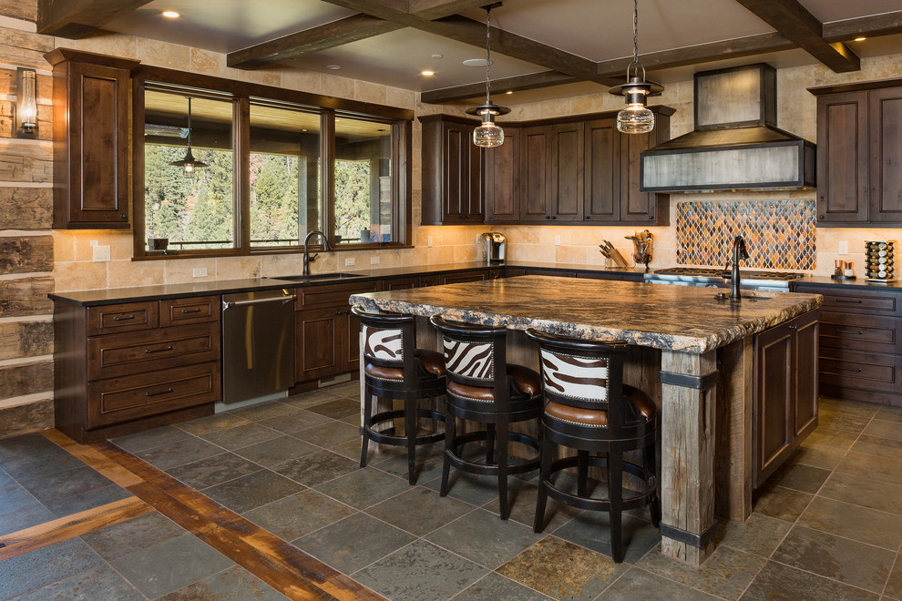 Open concept kitchen - large rustic u-shaped slate floor and multicolored floor open concept kitchen idea with an undermount sink, brown cabinets, granite countertops, beige backsplash, stone tile backsplash, paneled appliances, an island and multicolored countertops
