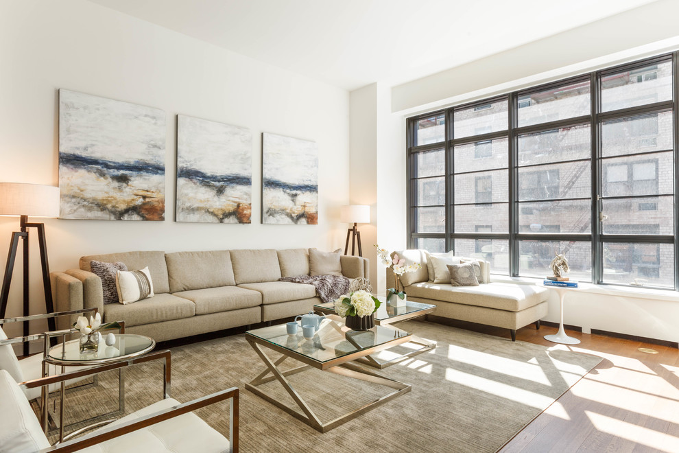 Transitional living room in New York with white walls and light hardwood floors.