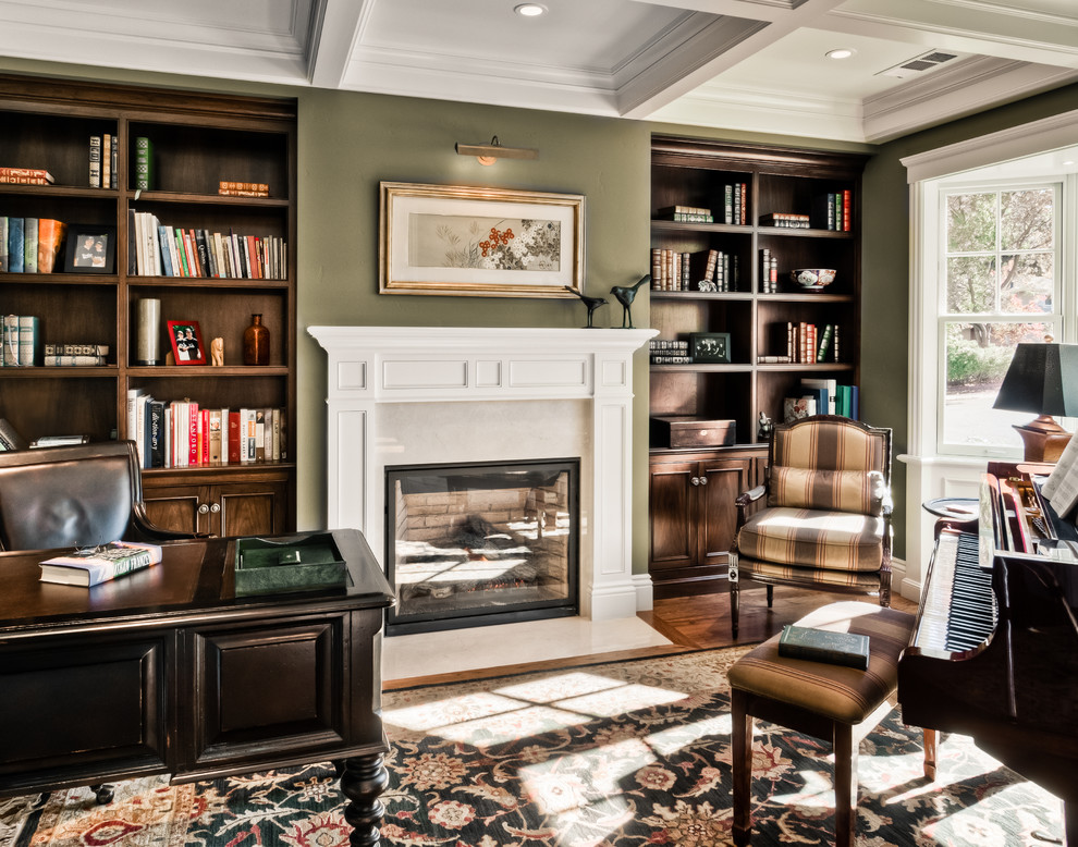 Design ideas for a mid-sized traditional study room in San Francisco with green walls, dark hardwood floors, a standard fireplace, a plaster fireplace surround and a freestanding desk.
