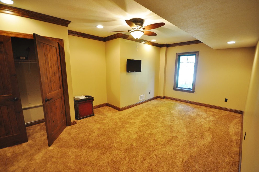 This is an example of a large country guest bedroom in Other with beige walls and carpet.