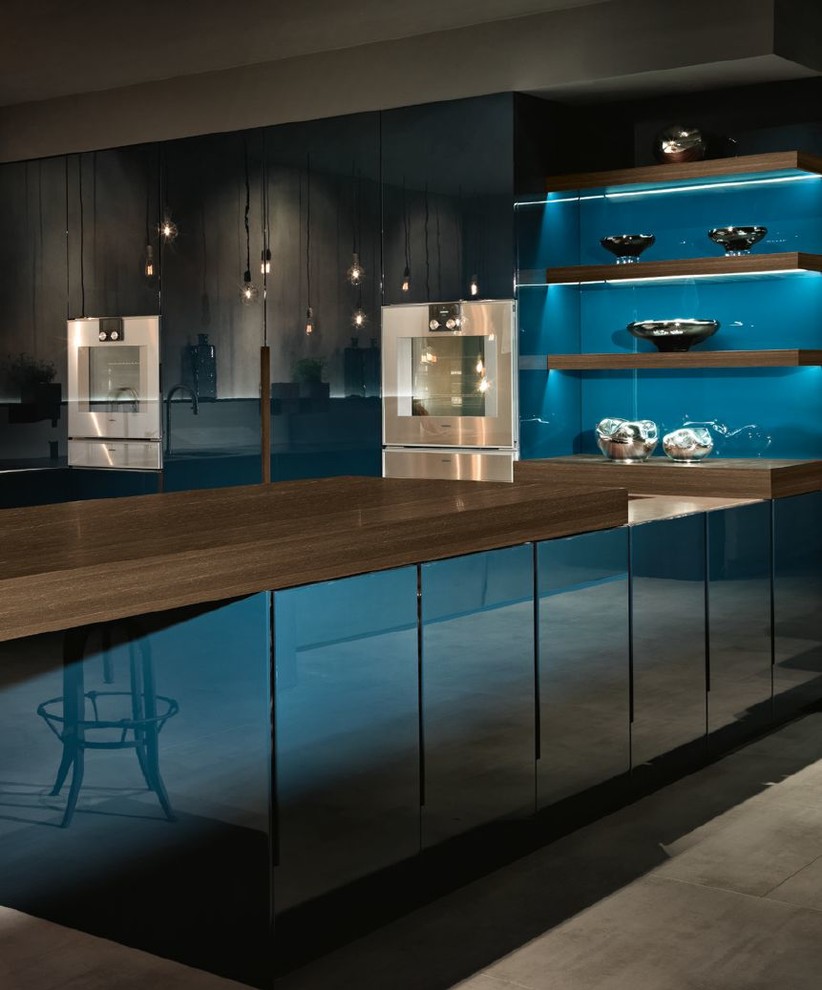 Inspiration for an expansive contemporary u-shaped kitchen pantry in San Francisco with an integrated sink, flat-panel cabinets, blue cabinets, stainless steel benchtops, grey splashback, stainless steel appliances, concrete floors, a peninsula, grey floor and grey benchtop.