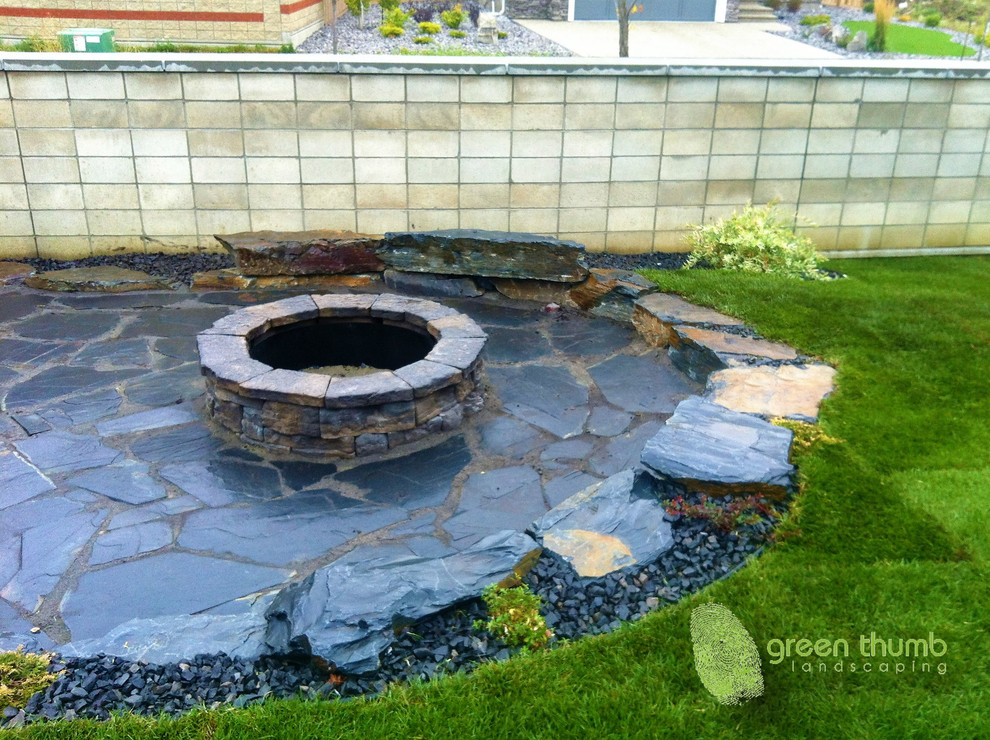 Inspiration for a rustic full sun front yard stone landscaping in Edmonton with a fire pit for summer.