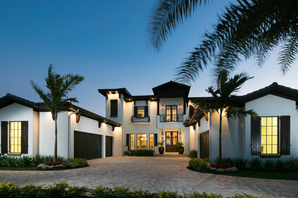 This is an example of a large mediterranean two-storey stucco white exterior in Miami with a flat roof.