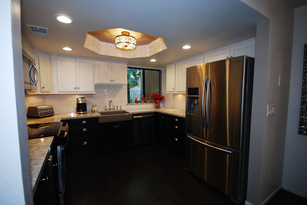 Small transitional u-shaped porcelain tile eat-in kitchen photo with a farmhouse sink, shaker cabinets, white cabinets, quartz countertops, white backsplash, subway tile backsplash, stainless steel appliances and gray walls