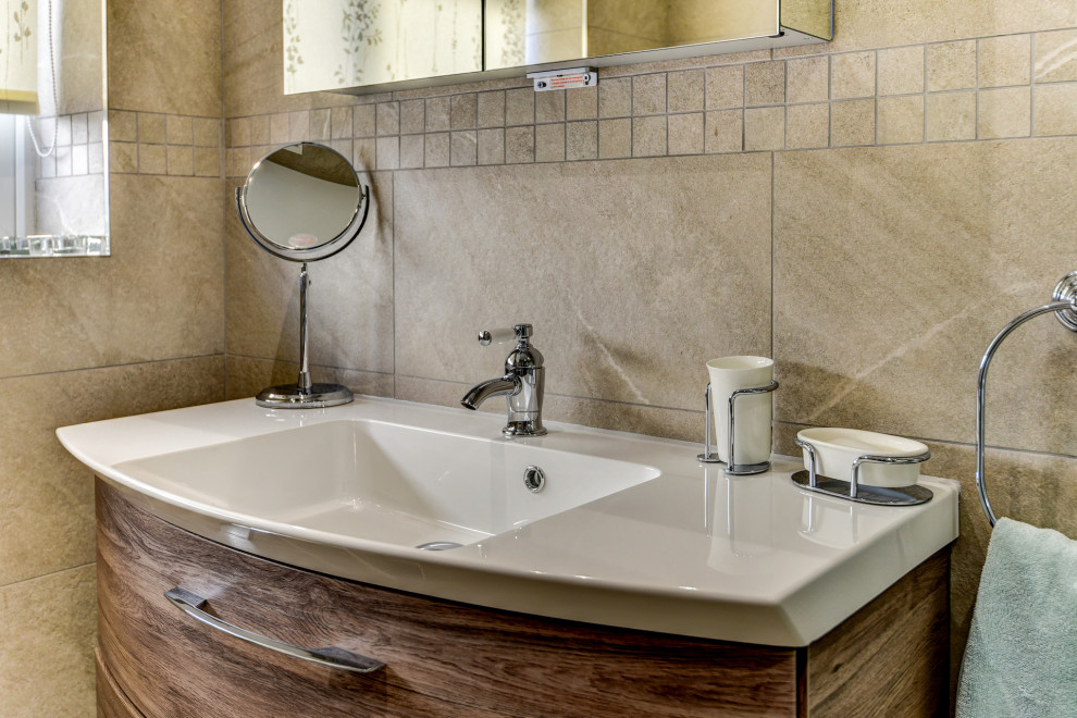 Cette image montre une petite salle d'eau en bois brun avec une douche d'angle, WC séparés, un carrelage beige, des carreaux de céramique, un mur beige, un sol en vinyl, un lavabo posé, un sol beige, une cabine de douche à porte battante, meuble simple vasque et meuble-lavabo suspendu.