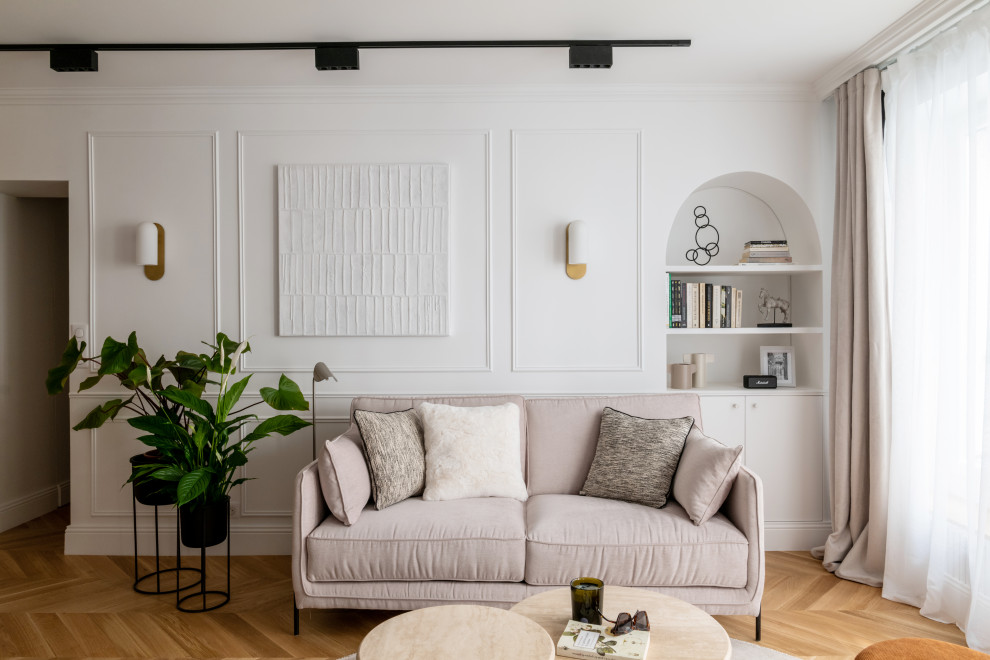 Пример оригинального дизайна: открытая гостиная комната среднего размера, в белых тонах с отделкой деревом:: освещение в стиле неоклассика (современная классика) с белыми стенами, светлым паркетным полом, телевизором на стене, коричневым полом и панелями на стенах