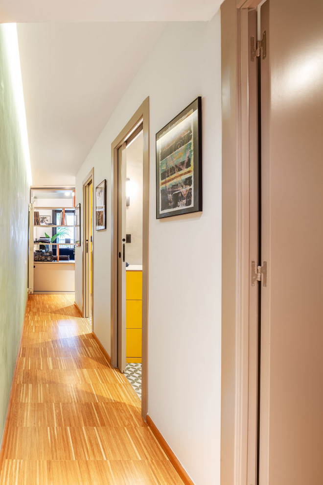 Réalisation d'un petit couloir design avec un mur vert, un sol en bois brun et un sol marron.
