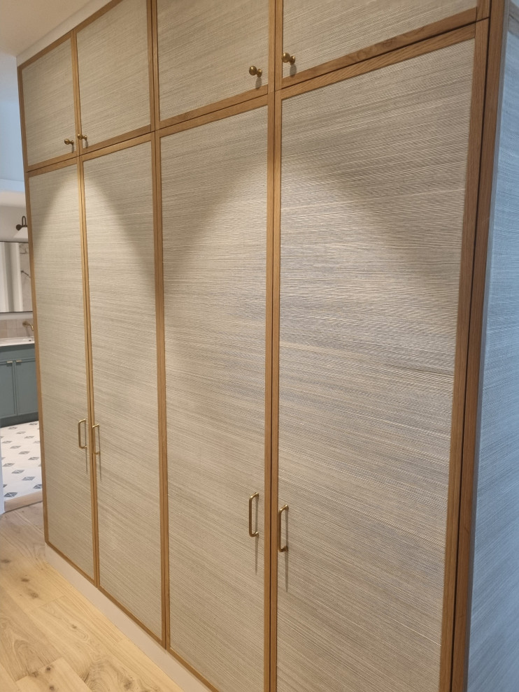 Bedroom - large modern master plywood floor bedroom idea in London with beige walls