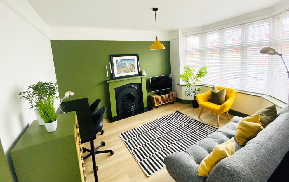 ドーセットにある低価格の中くらいなモダンスタイルのおしゃれなホームオフィス・書斎 (緑の壁、クッションフロア、木材の暖炉まわり、自立型机、ベージュの床) の写真