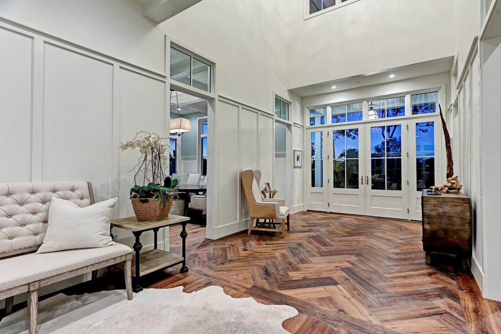 This is an example of an expansive country foyer in Los Angeles with white walls, medium hardwood floors, a double front door, a gray front door and brown floor.