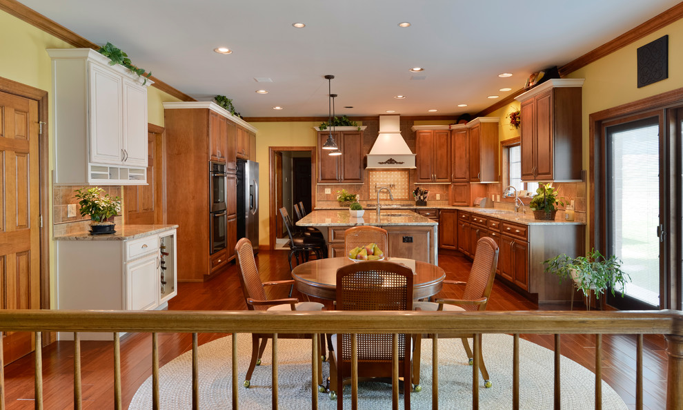 Inspiration for a large transitional u-shaped medium tone wood floor eat-in kitchen remodel with beaded inset cabinets, medium tone wood cabinets, granite countertops, beige backsplash, mosaic tile backsplash, stainless steel appliances and an island