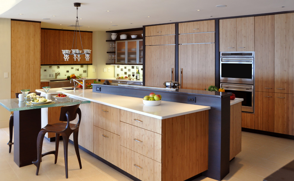 Contemporary eat-in kitchen in New York with flat-panel cabinets, light wood cabinets and panelled appliances.