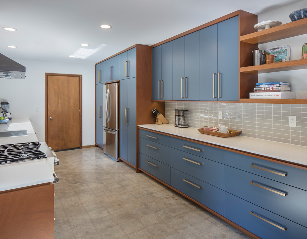 Inspiration for a mid-sized midcentury galley eat-in kitchen in Kansas City with an undermount sink, flat-panel cabinets, blue cabinets, quartz benchtops, grey splashback, porcelain splashback, stainless steel appliances, concrete floors, with island and grey floor.