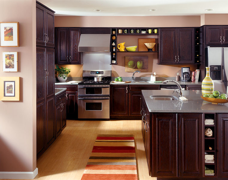 Eat-in kitchen - large eclectic u-shaped light wood floor eat-in kitchen idea in Other with an undermount sink, raised-panel cabinets, dark wood cabinets, stainless steel appliances and an island