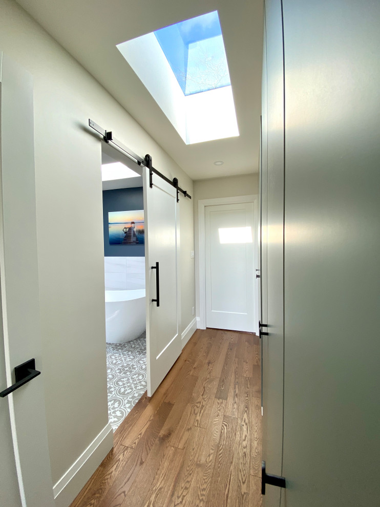 Photo of a large contemporary gender-neutral dressing room in Toronto with flat-panel cabinets, green cabinets, medium hardwood floors and brown floor.