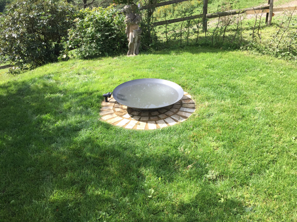 Inspiration for a large contemporary backyard full sun garden in Sussex with with pond and natural stone pavers.